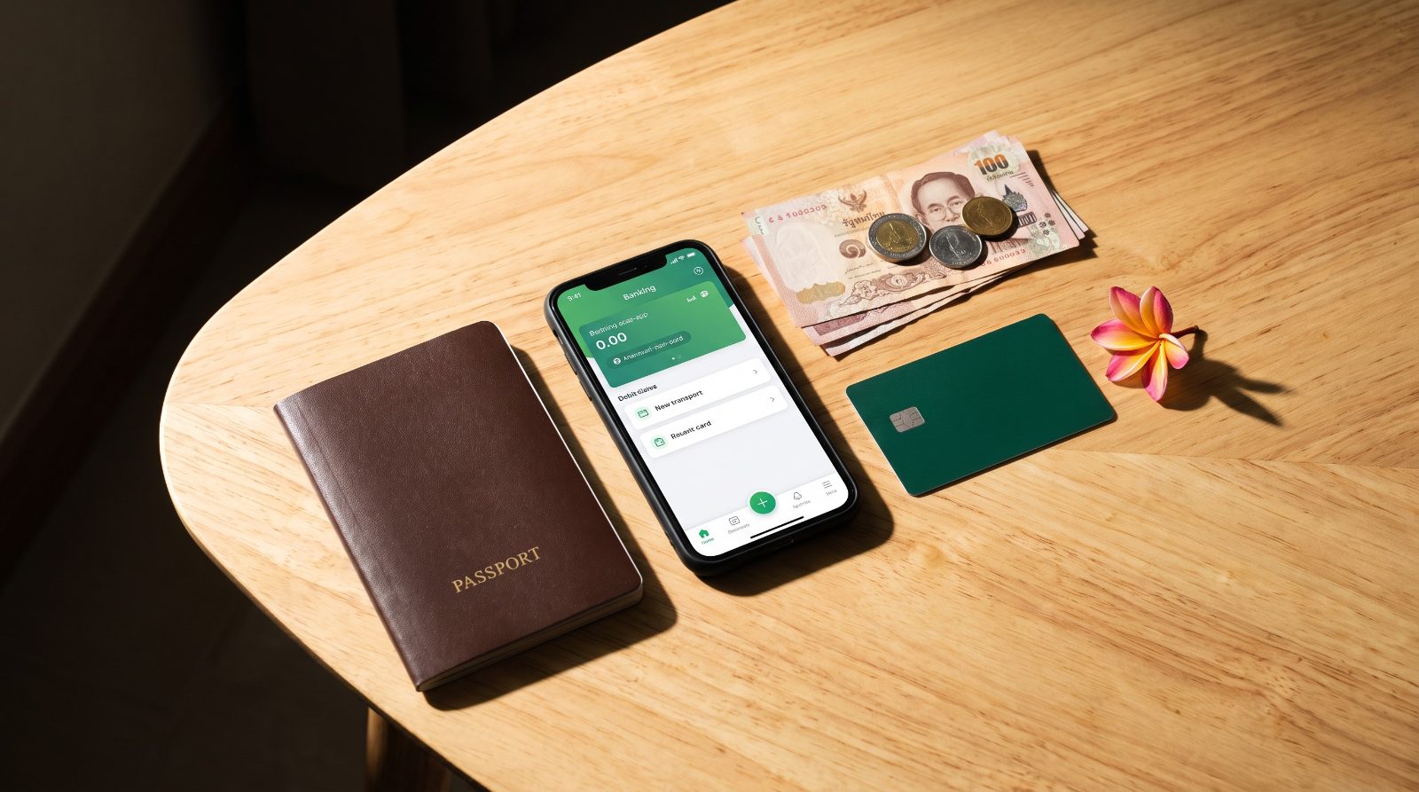 パスポート、スマートフォン、デビットカード、タイバーツを並べた旅行準備のイメージ